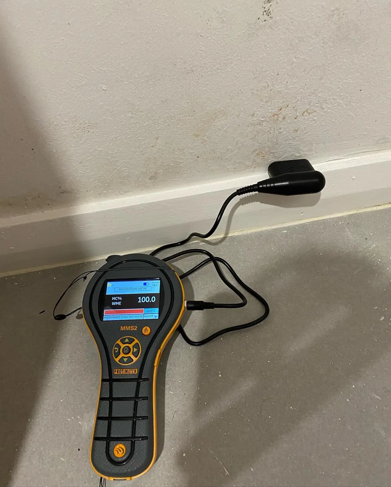 Technician taking a moisture reading during water damage restoration